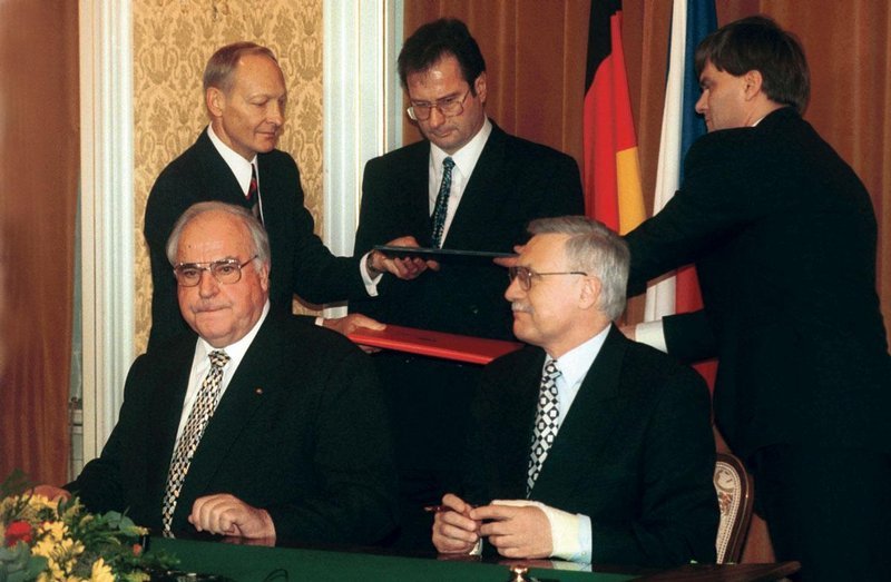 1992. Německý kancléř Helmut Kohl (vlevo) a český premiér Václav Klaus podepisují deklaraci. V pozadí uprostřed stojí ministr zahraničí Německa Klaus Kinkel