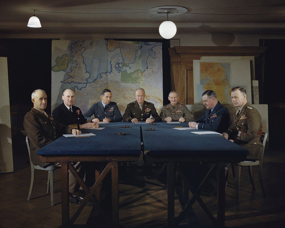Únor 1944, americký generál Dwight D. Eisenhower (pozdější prezident USA, sedí uprostřed v hnědé uniformě) a jeho velitelé ve vrchním velitelství spojeneckých sil v Londýně. 