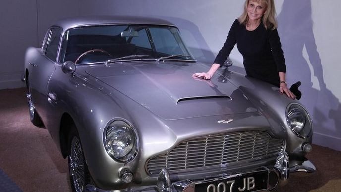 Jedna z hereček "Bond-girl" Britt Eklandová pózuje u agentova slavného vozu Aston Martin DB5 Jedna z hereček "Bond-girl" Britt Eklandová pózuje u agentova slavného vozu Aston Martin DB5