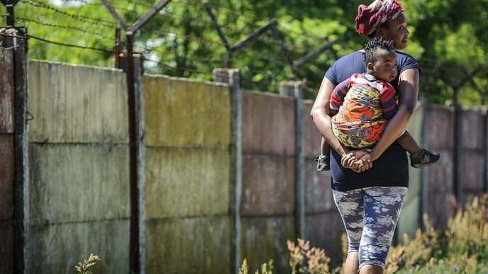 Migrantka se svým dítětem u zdi uprchlického tábora v maďarském Debrecíně Migrantka se svým dítětem u zdi uprchlického tábora v maďarském Debrecíně