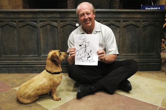 Jim Davis s nakreslenou postavičkou psa Odieho Jim Davis s nakreslenou postavičkou psa Odieho