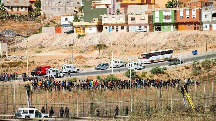 Do světa za zdí. Lidé se snaží překonat plot dělící Maroko a Španělskou autonomní oblast Melilla, která leží na severoafrickém pobřeží Do světa za zdí. Lidé se snaží překonat plot dělící Maroko a Španělskou autonomní oblast Melilla, která leží na severoafrickém pobřeží