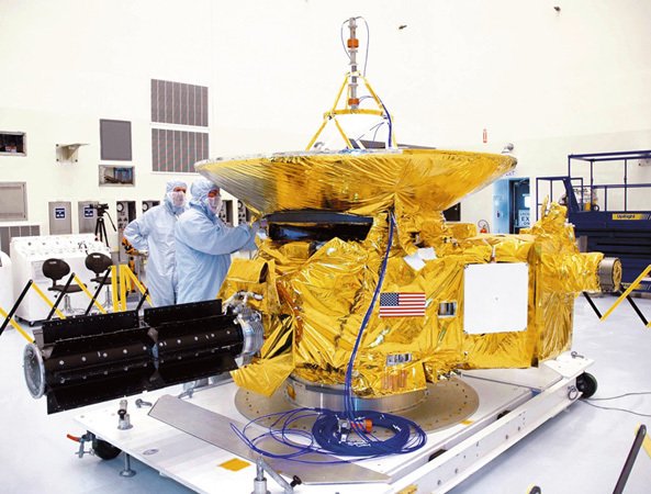 Laboratoř NASA - listopad 2009: Technici připravují ve sterilně čisté laboratoři sondu New Horizons na předváděčku před novináři