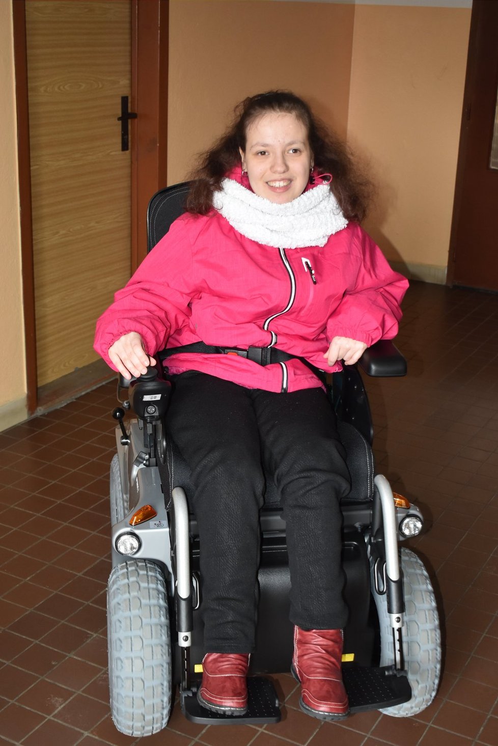 Šťastná Adélka při své první jízdě na elektrickém vozíku.