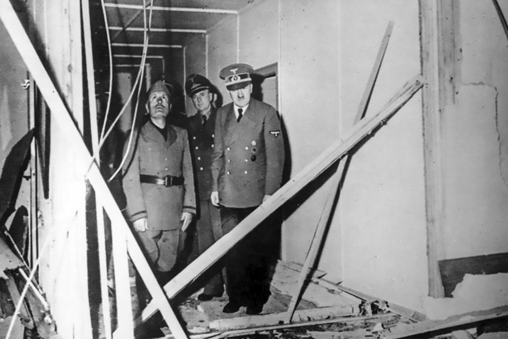 Adolf Hitler ukazuje Benitu Mussolinimu stav místnosti, kde měl být zabit pomocí bomby