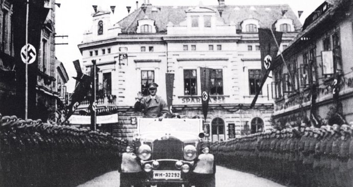 Hitler vzpřímený nad předním sklem svého mercedesu projíždí 6. října 1938 Cvikovem