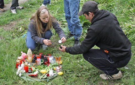 Na náhradním poklopu jímky příbuzní zapalují svíčky.