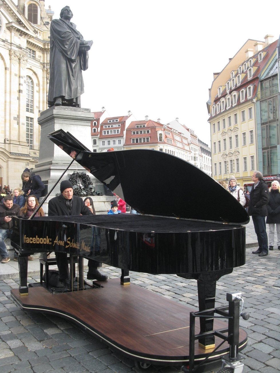 Advent na Neumarktu má mnohem decentnější atmosféru než Štrýclmarkt. O víkendech jeho kolorit dotváří i klavírista, který koncertuje přímo pod sochou Martina Luthera.