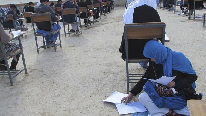 Mladá Afghánka zvládá přijímací test i péči o dítě zároveň.