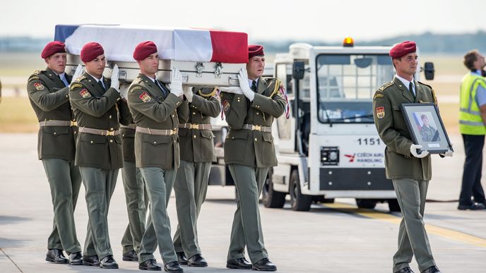 Rakve s padlými příslušníky afgánské mise vynesli vojáci postupně na letištní plochu. V čele šel voják nesoucí fotografii padlého