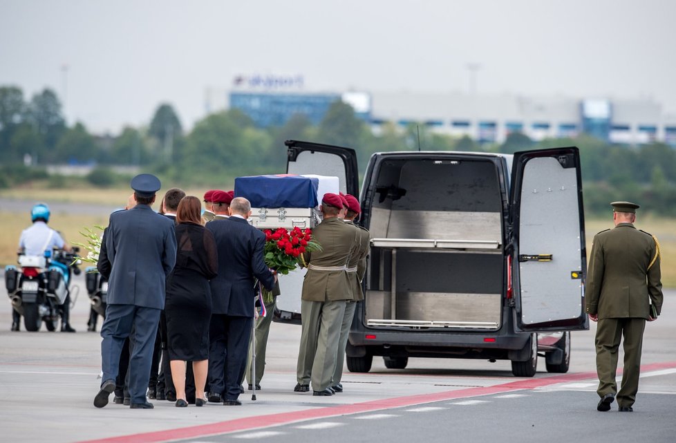 Vojáci nakládají těla svých kolegů v rakvích do připravených pohřebních vozů.