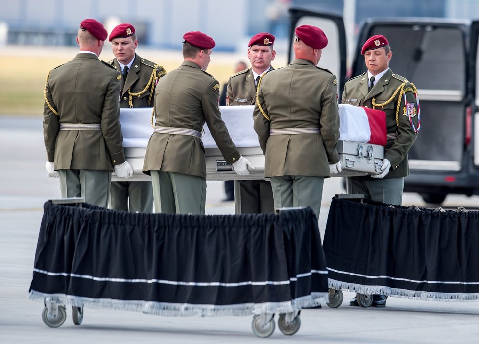 Rakve s ostatky padlých vynesla vojenská stráž na katafalky.