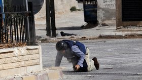 Reportér AFP Sammy Ketz padl k zemi v Sýrii ve starobylém křesťanském městě Maanula nedaleko Damašku během bojů mezi vládními vojáky a rebely (18. 9. 2013).