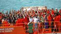 Afričtí uprchlíci na záchranné lodi mávají rybářůmcestou do španělského přístavu Tarifa