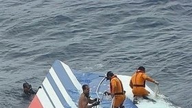 Záchranáíři vyzvedávají trosky letadla z oceánu.
