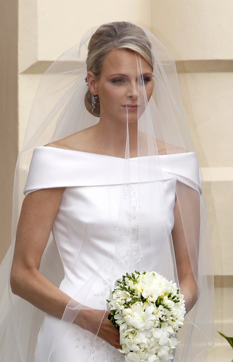 Nevěsta, doprovázená sedmi družičkami, byla oblečena v bílé róbě s dlouhou vlečkou a s krajkami ve formě květů od Armaniho.