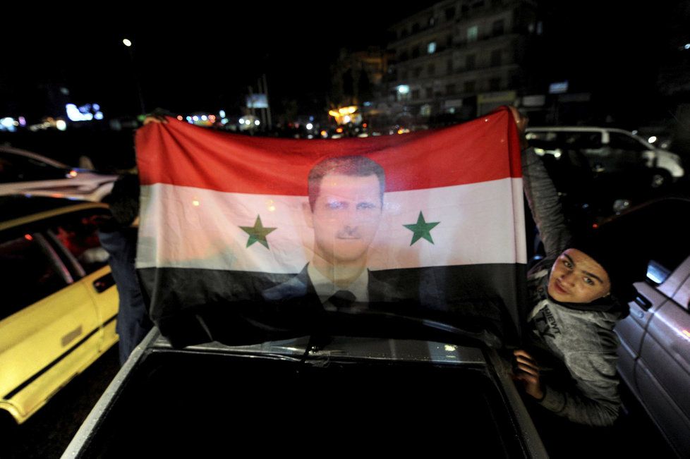 Lidé v ulicích Aleppa slaví vítězství syrské armády a jejích spojenců.