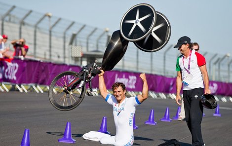 Zanardi zvedá svůj handbike vítězně nad hlavu.