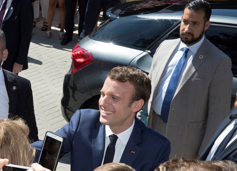 Emmanuel Macron se vítá s příznivci. V pozadí Alexandre Benalla, prezidentův někdejší osobní strážce (foto z 11. června 2017)