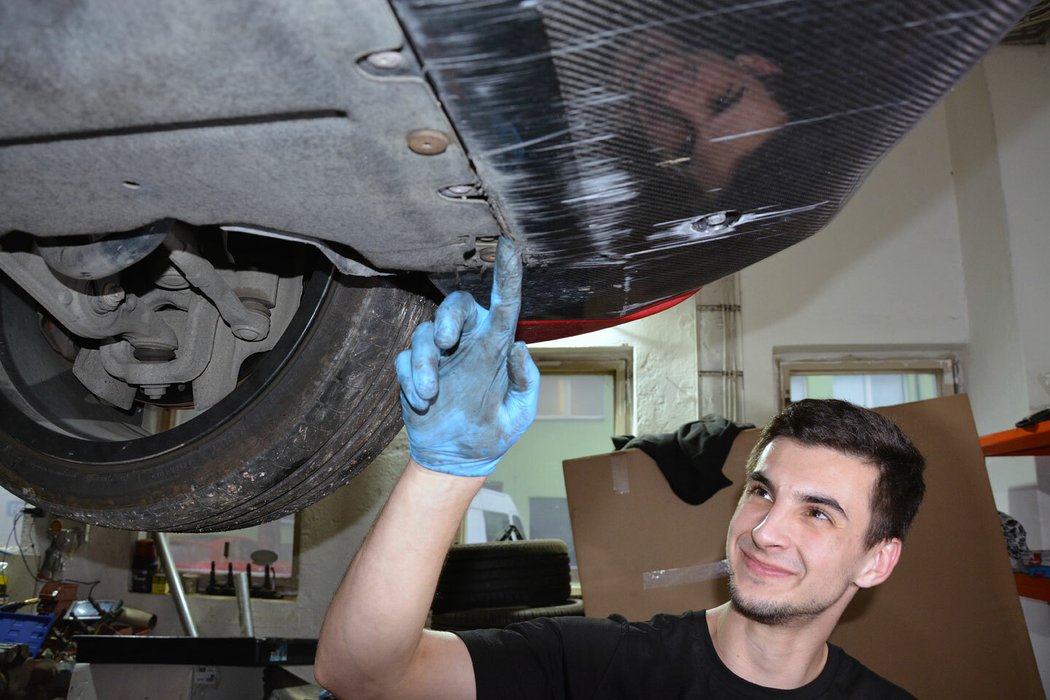 Mechanik a specialista na italské vozy Tomáš Kovačík ukazuje typické poškození výsuvného předního karbonového spojleru verze QV. Toto je čistě estetické, které není potřeba řešit.