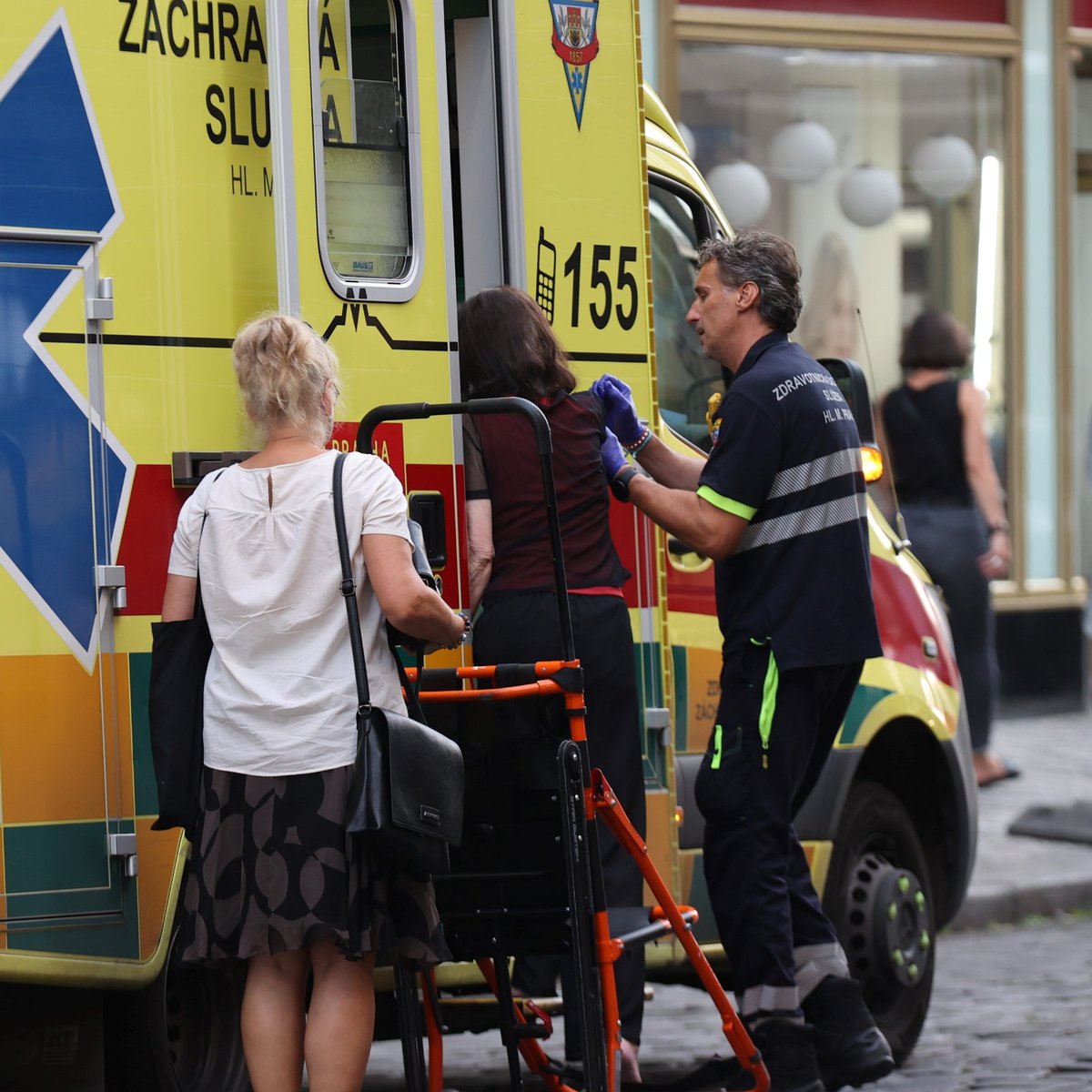 Záchranáři pomáhají herečce Alici Šnirychové do záchranky. 