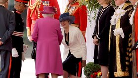 Premiérka Theresa Mayová se klaní královně (2017).