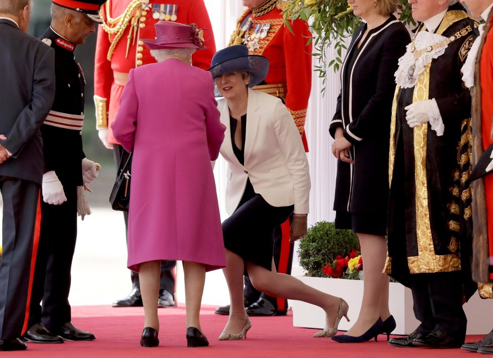 Premiérka Theresa Mayová se klaní královně (2017).
