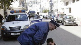 Demonstrace v Alžíru provází pokusy o tzv. živé pochodně. Tento muž se pokusil upálit 6. února. Na snímku je dále policista a novinář.