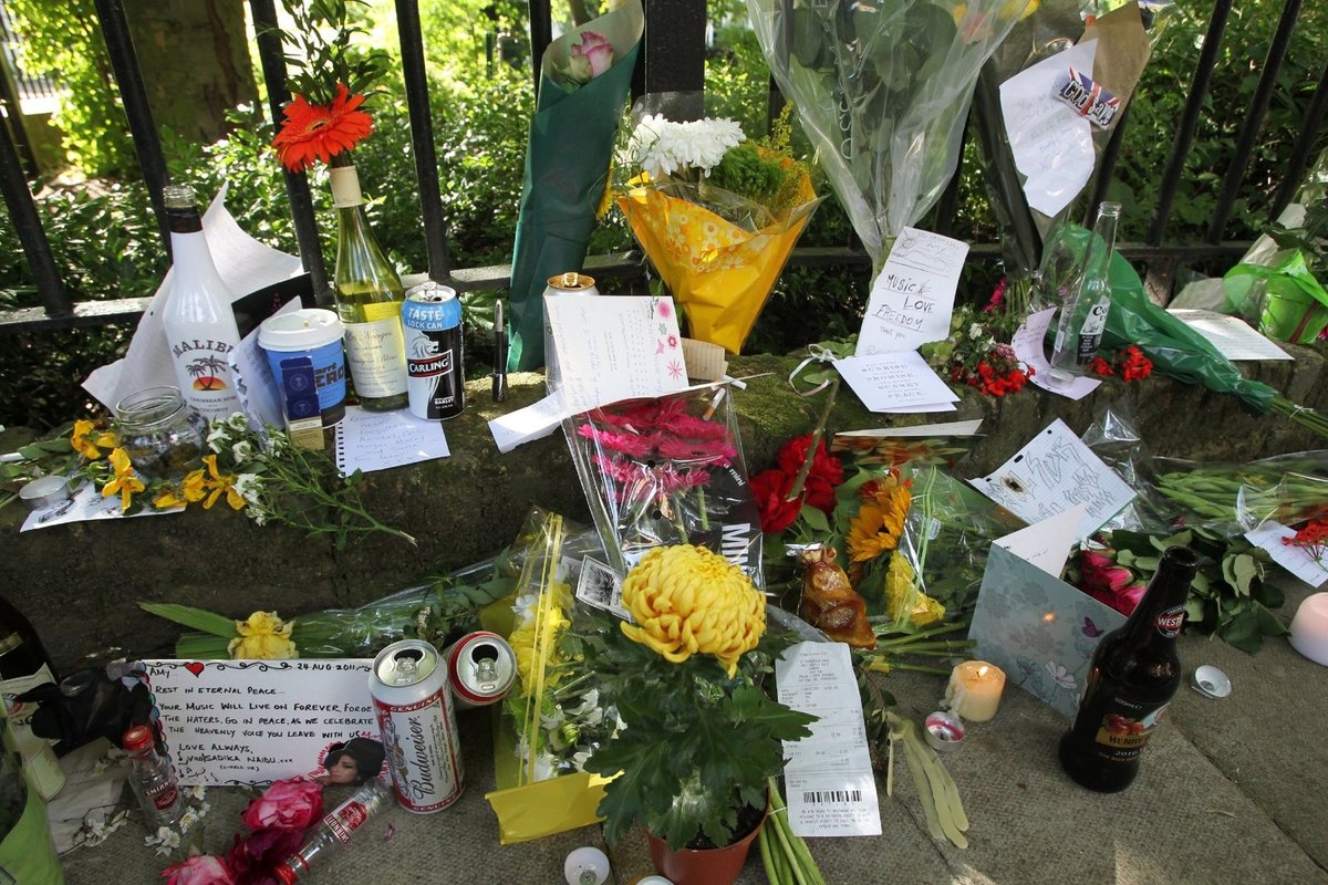 K domu zesnulé zpěvačky nosí fanoušci květiny, svíčky, vzkazy i fotografie.