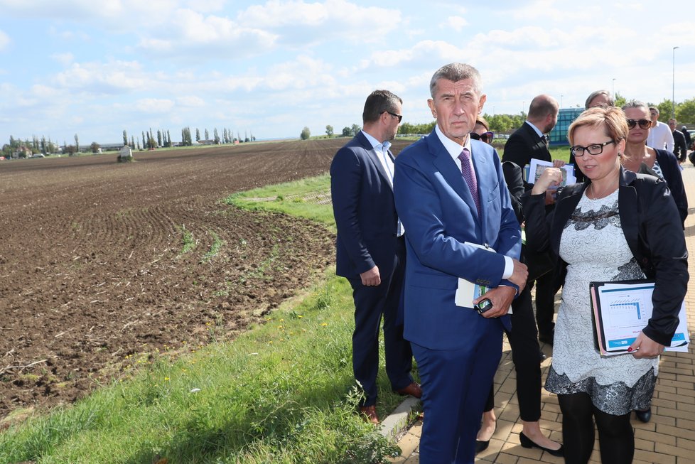 Andrej Babiš (ANO) mluvil u pole a metra v Letňanech o nové administrativní čtvrti. Vpravo šéfka Úřadu pro zastupování státu ve věcech majetkových Kateřina Arajmu (17. 9. 2019)