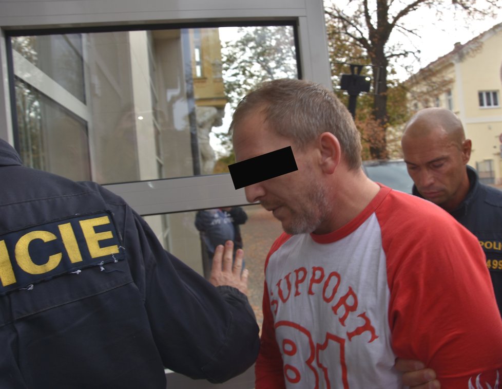 Policisté přivádějí k soudu v Rokycanech Alberta A. (43), kterého viní, že ve čtvrtek střelil do hlavy svou přítelkyni (37).