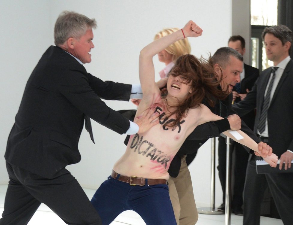 Vyvádění jedné z demonstrantek, která se snažila dostat k prezidentu Putinovi