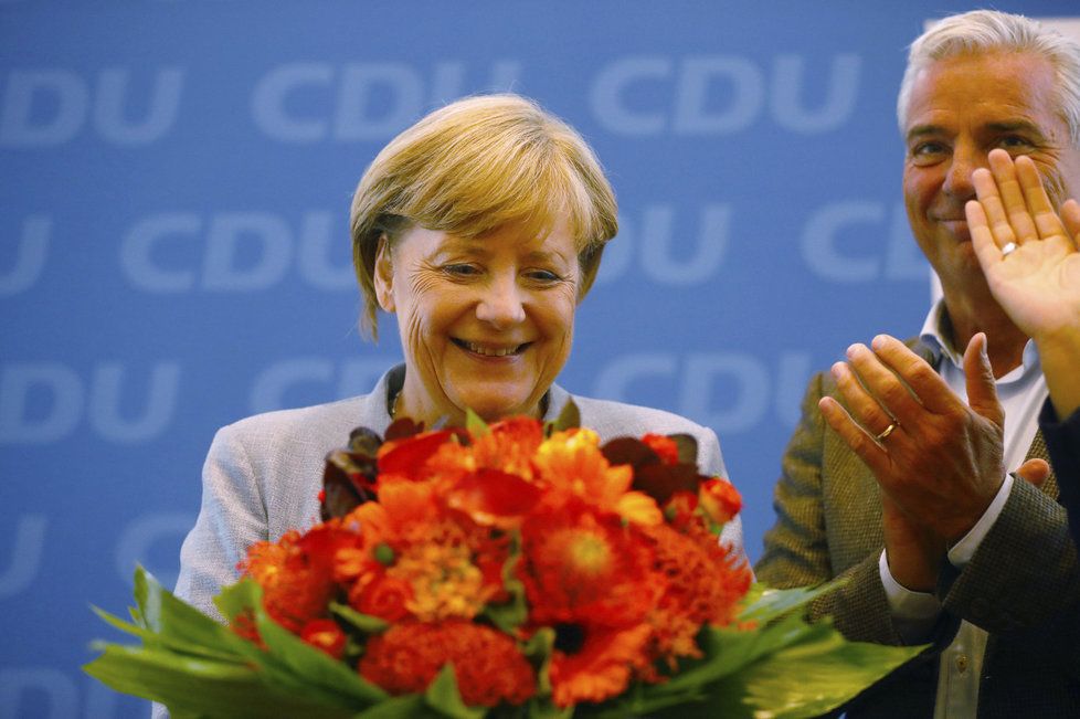 Merkelová den po volebním vítězství: V Berlíně na setkání lídrů dostala velkou kytici.
