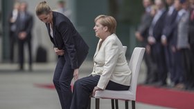 Německá kancléřka Angela Merkelová si den po třetím třesu na ceremonii s dánskou premiérkou Mette Frederiksenovou radši sedla (11. 7. 2019)