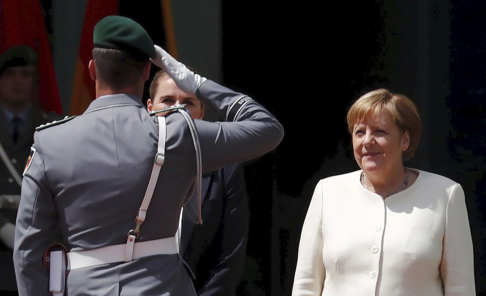 Německá kancléřka Angela Merkelová si den po třetím třesu na ceremonii s dánskou premiérkou Mette Frederiksenovou radši sedla (11. 7. 2019).