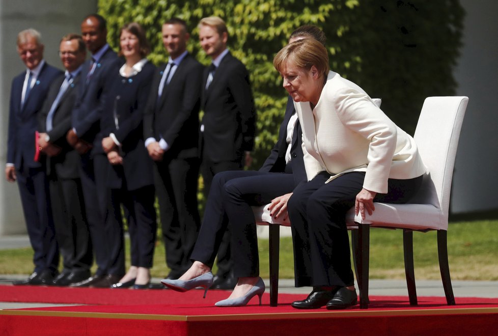 Německá kancléřka Angela Merkelová si den po třetím třesu na ceremonii s dánskou premiérkou Mette Frederiksenovou radši sedla (11. 7. 2019).