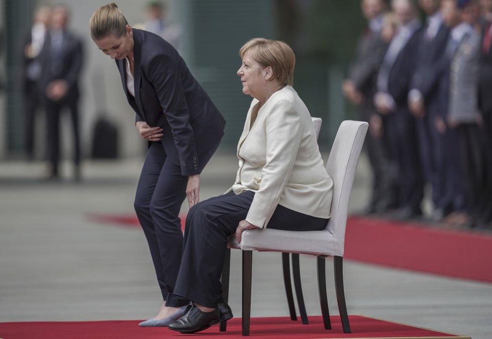 Německá kancléřka Angela Merkelová si den po třetím třesu na ceremonii s dánskou premiérkou Mette Frederiksenovou radši sedla (11. 7. 2019).