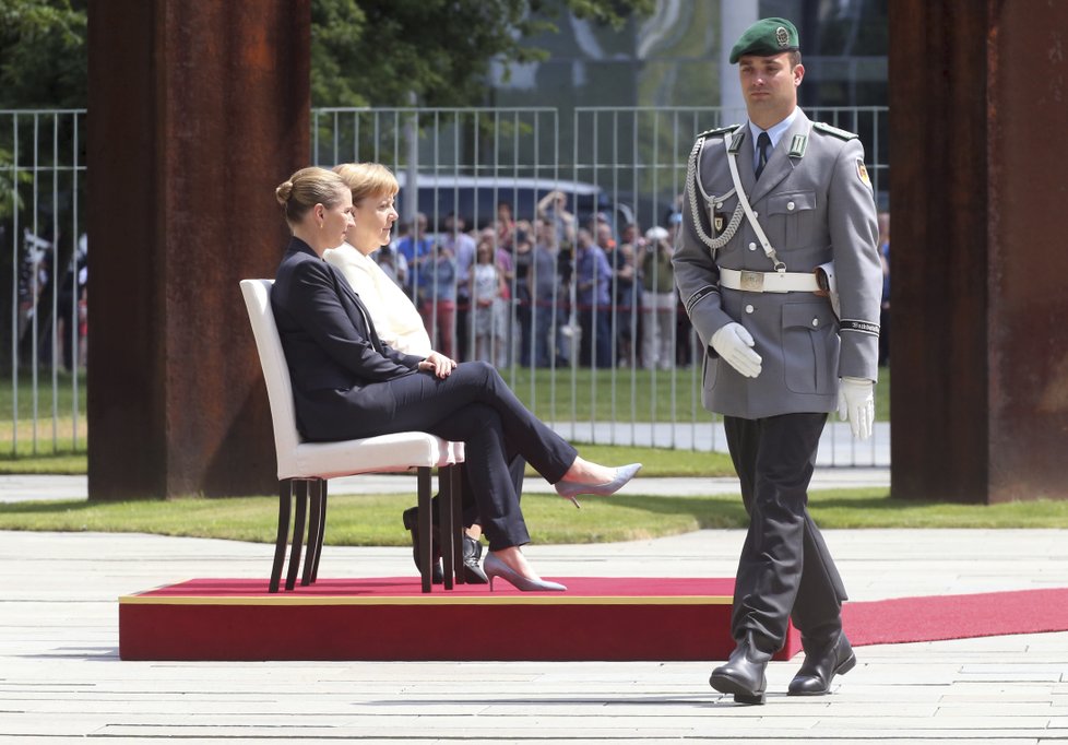 Německá kancléřka Angela Merkelová si den po třetím třesu na ceremonii s dánskou premiérkou Mette Frederiksenovou radši sedla (11. 7. 2019)