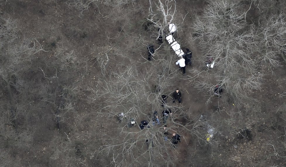 Policie přenáší tělo Aničky do pohřebního vozu.