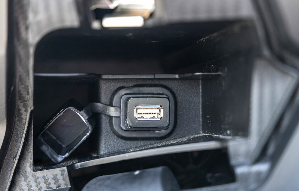 Mobil lze dobíjet přes USB v kastlíku vlevo pod řídítky. Přes bluetooth ho lze spojit se skútrem a využívat aplikaci Aprilia Mia.