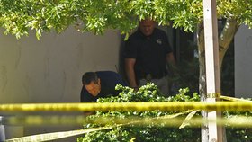 Policista dává pod plachtu jedno z mrtvých těl