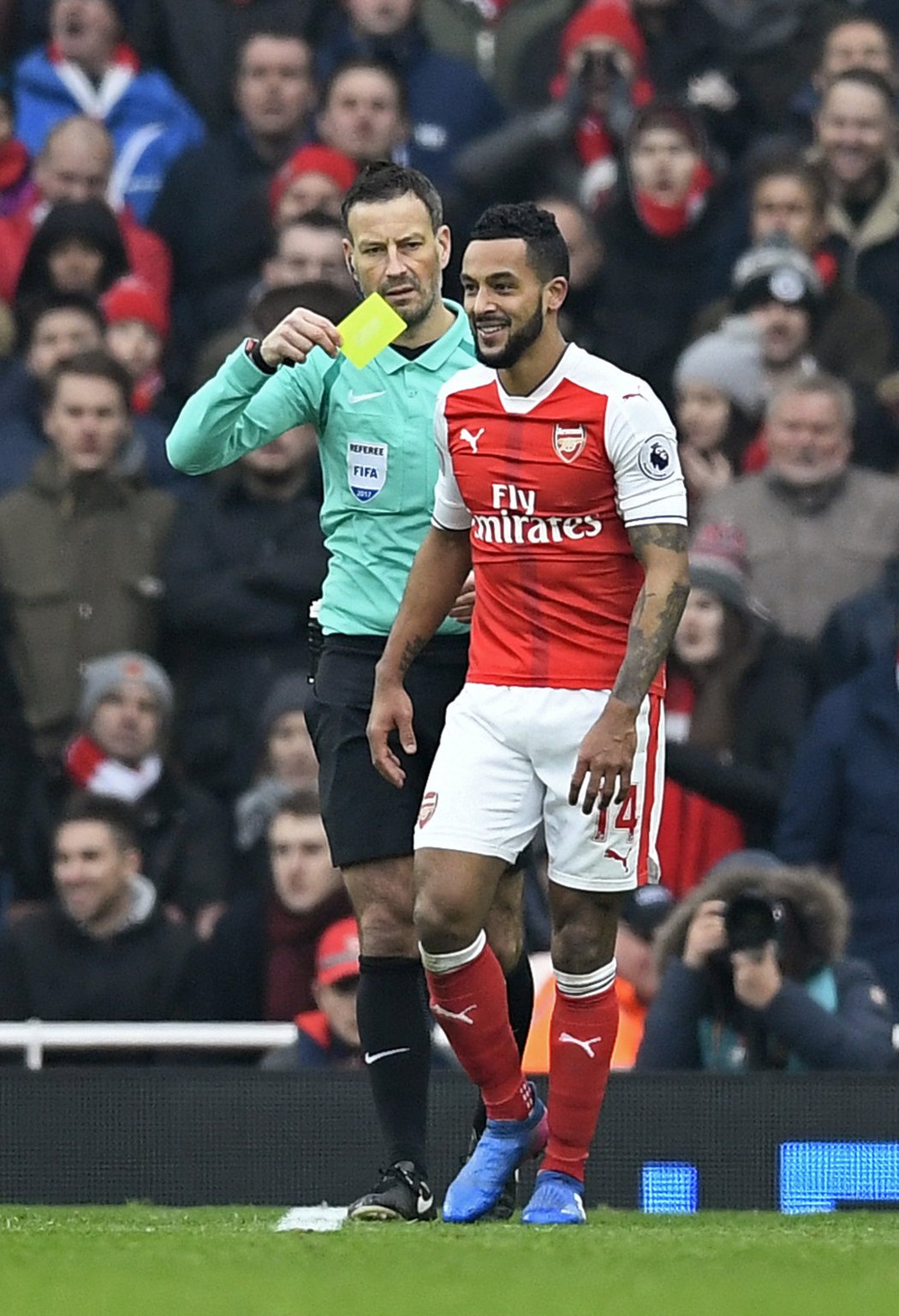 Theo Walcott bere žlutou kartu od Marka Clattenburga s úsměvem