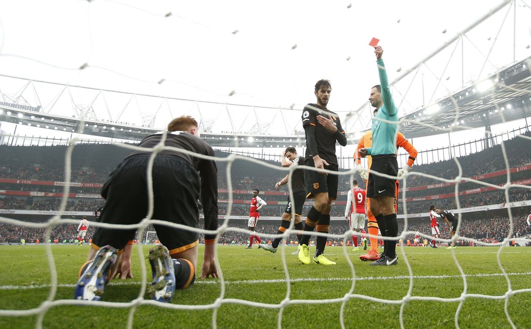 Mark Clattenburg ukazuje v závěru zápasu červenou kartu hráči Hullu za chycení balonu rukou z brankové čáry