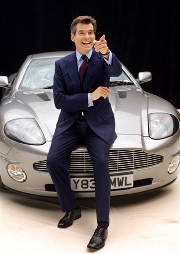 Pierce Brosnan jako jako James Bond před vozem Aston Martin.