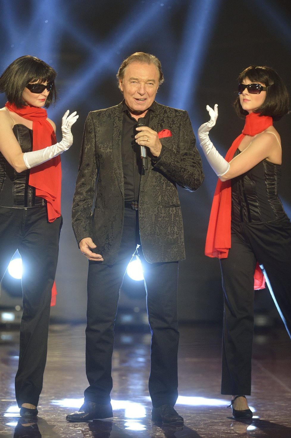 Karel Gott zazpíval oprášený hit z nové desky za asistence křoví tanečníků, jež kostýmy i choreografií evokovali vzpomínky na dobu totalitní zábavy a TV diváky nadšeně sledované koncerty mistra z divadla ve Slaném…