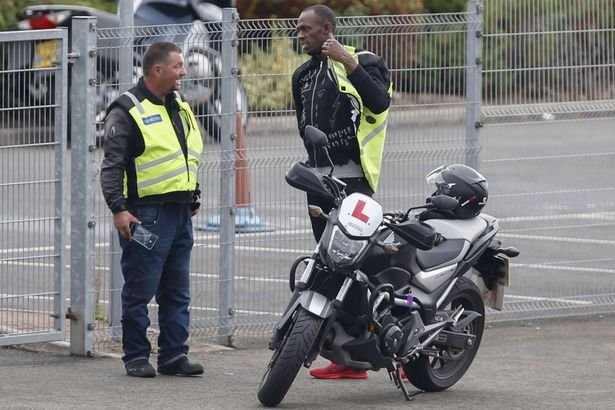 Bolt si obléká vestu, aby mohl usednout na motocykl. Instruktor byl vykulený, koho na jízdách má.