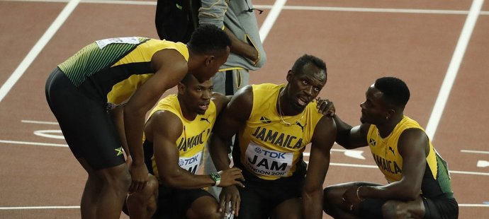 Usain Bolt po boku svých parťáků z jamajské štafety po svém poslední závodu na MS, který kvůli zranění nedokončil