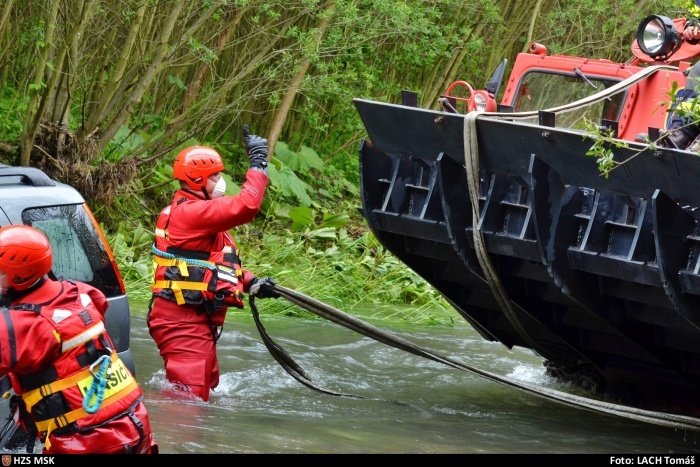Hasiči zachraňovali osádku auta, které strhl proud Morávky. Řidič se snažil v Raškovicích přebrodit rozvodněnou řeku.