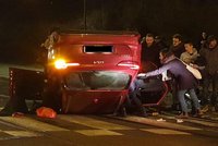 Děsivá nehoda v Holešovicích: Řidič narazil do semaforu a s autem skončil na střeše, tři lidé se zranili