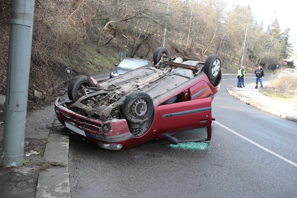 Auto v Křížové ulici na Smíchově skončilo na střeše, 8. března 2021.